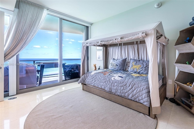 bedroom featuring a water view and multiple windows