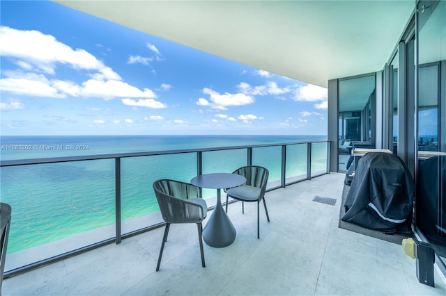 balcony with a water view and a view of the beach