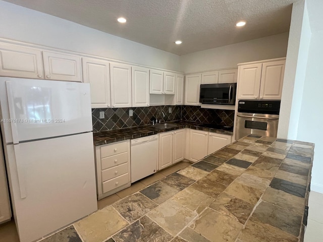 kitchen with decorative backsplash, white cabinetry, sink, and white appliances