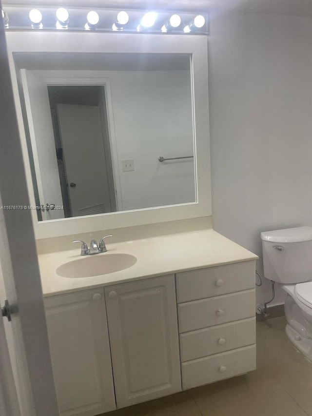 bathroom featuring vanity, toilet, and tile patterned flooring