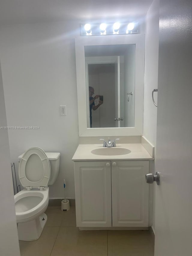 bathroom featuring toilet, vanity, and tile patterned flooring