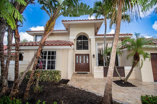 mediterranean / spanish-style home featuring a garage and french doors