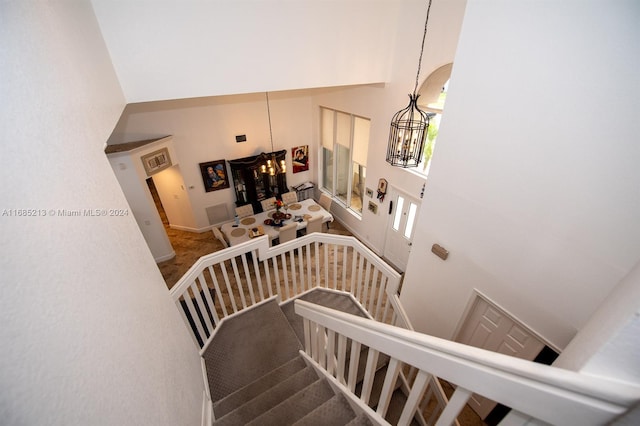 stairway with a high ceiling and a chandelier