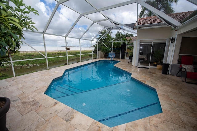 view of pool featuring glass enclosure and a patio area