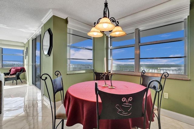 tiled dining area featuring a notable chandelier, ornamental molding, and a textured ceiling