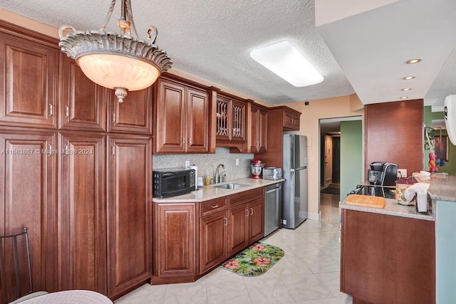 18011 Biscayne Blvd Unit 1705, Aventura, FL 33160 - kitchen featuring appliances with stainless steel finishes, glass insert cabinets, decorative backsplash, a textured ceiling, and light stone countertops