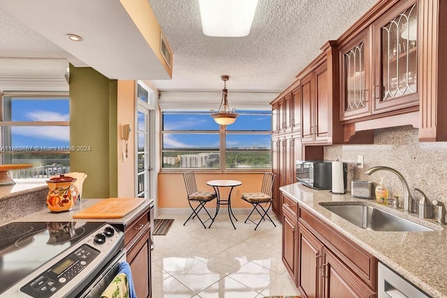 18011 Biscayne Blvd Unit 1705, Aventura, FL 33160 - kitchen with stainless steel appliances, glass insert cabinets, hanging light fixtures, decorative backsplash, and light stone countertops