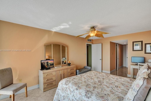 bedroom with ceiling fan and a textured ceiling