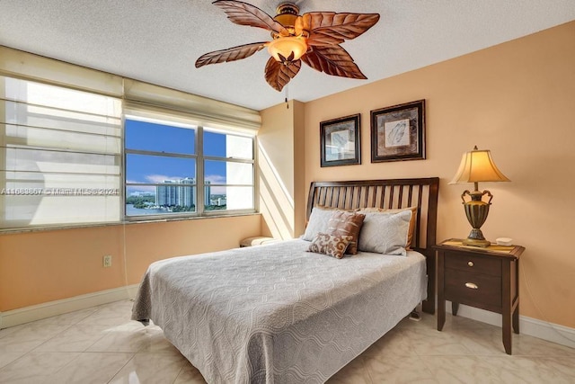 bedroom with ceiling fan and a textured ceiling