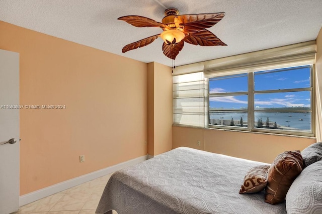 18011 Biscayne Blvd Unit 1705, Aventura, FL 33160 - bedroom featuring a ceiling fan, a water view, and a textured ceiling