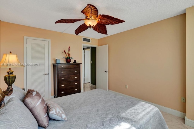 bedroom featuring a textured ceiling, a closet, and ceiling fan