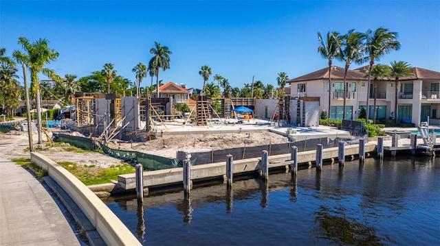 view of dock with a balcony and a water view