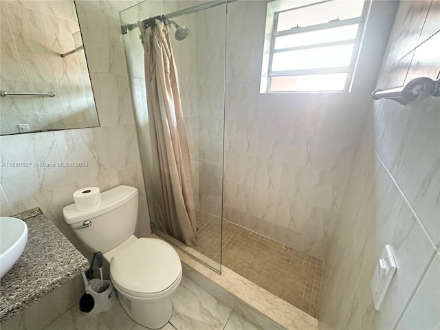 bathroom featuring tile walls, walk in shower, toilet, and vanity