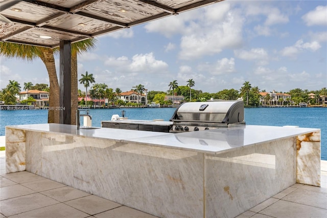 view of patio / terrace featuring area for grilling, a grill, a dock, and a water view