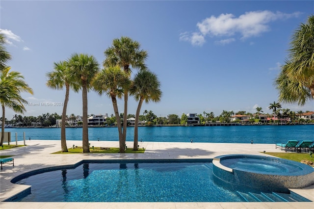 view of swimming pool with an in ground hot tub and a water view