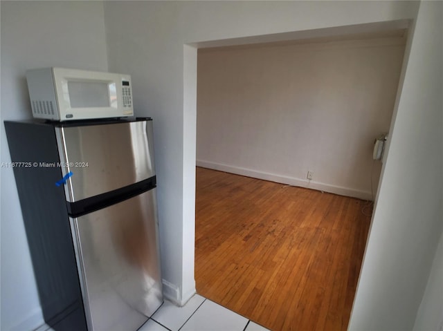 kitchen with hardwood / wood-style flooring and stainless steel refrigerator