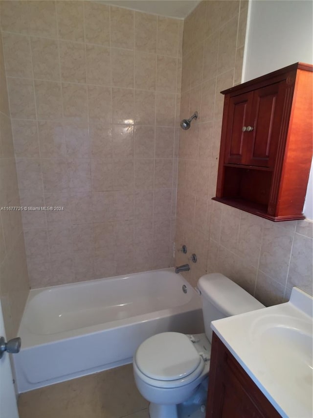 full bathroom featuring tasteful backsplash, tile walls, toilet, vanity, and tiled shower / bath combo