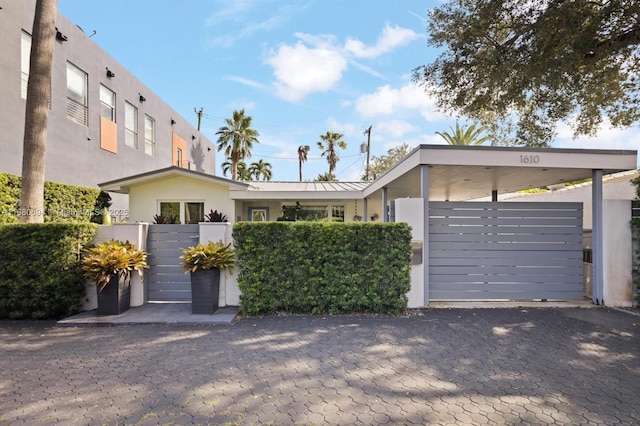 1610 S Bayshore Dr, Miami, FL 33133 - contemporary home featuring a fenced front yard, stucco siding, a gate, a garage, and decorative driveway