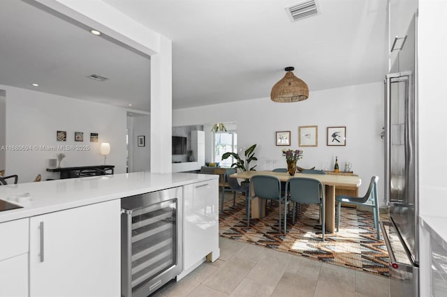 kitchen featuring white cabinetry and beverage cooler