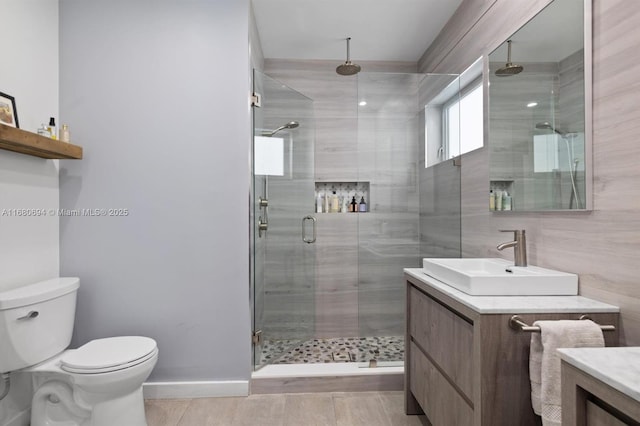 bathroom featuring vanity, toilet, and an enclosed shower