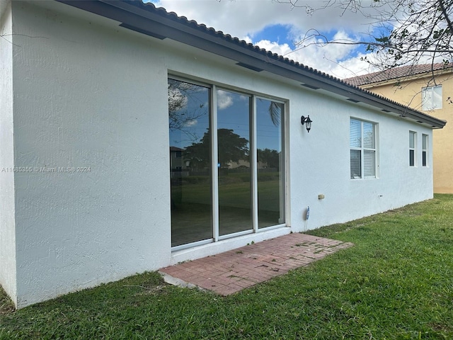 view of side of home with a yard