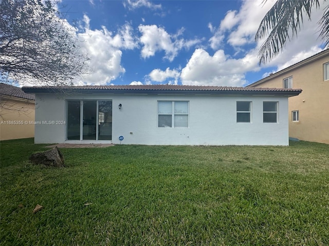 back of house featuring a lawn