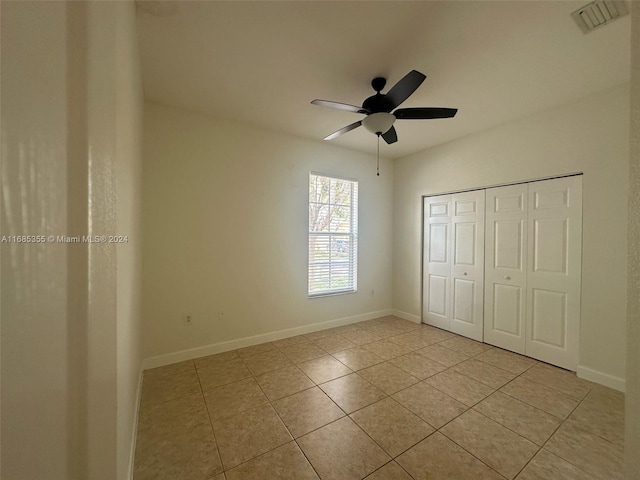 unfurnished bedroom with a closet, light tile patterned floors, and ceiling fan