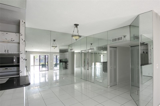 interior space with a textured ceiling and light tile patterned flooring