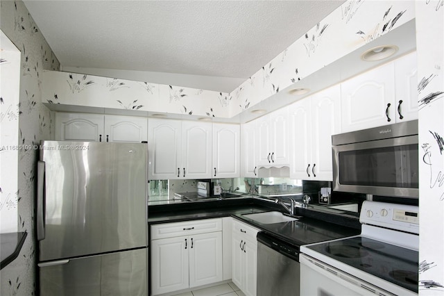 kitchen with white cabinetry, stainless steel appliances, a textured ceiling, and sink