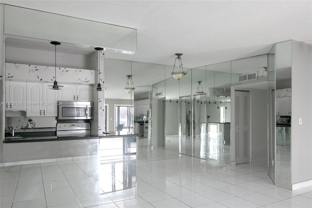 kitchen with white cabinetry, light tile patterned flooring, hanging light fixtures, and white range oven