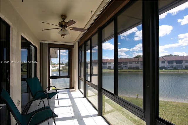 unfurnished sunroom with a water view and ceiling fan