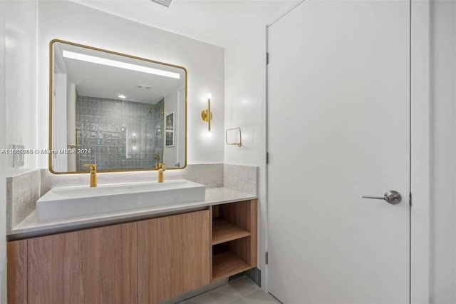 bathroom with vanity, a tile shower, and tile patterned floors