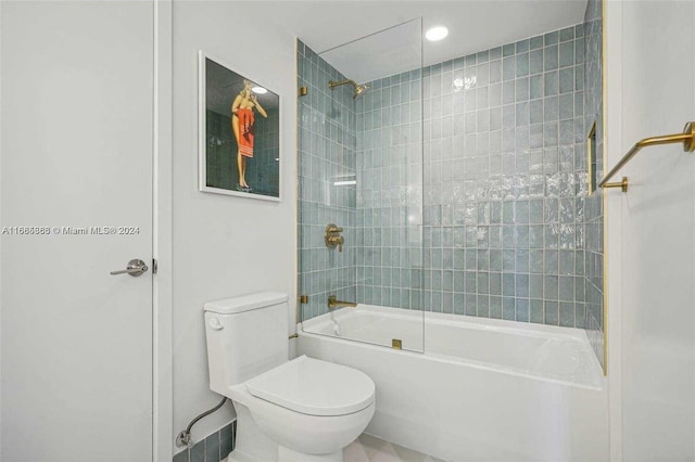 bathroom with toilet and tiled shower / bath