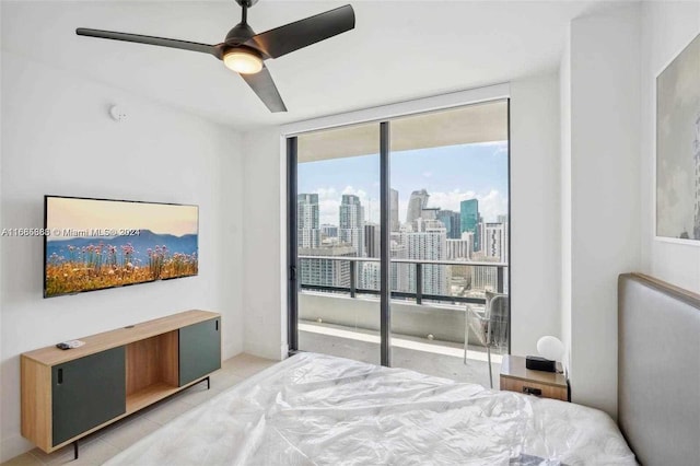 bedroom featuring ceiling fan, expansive windows, and light tile patterned flooring