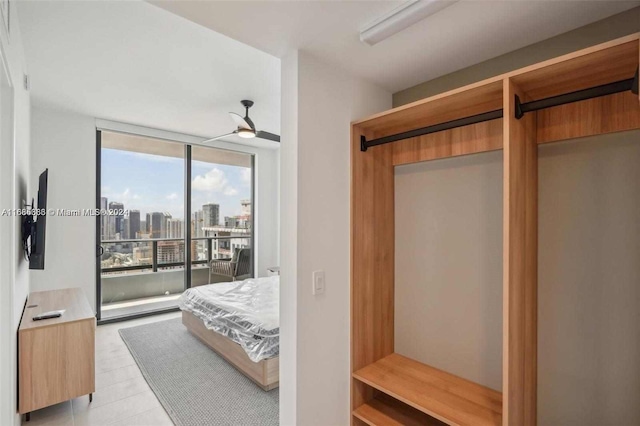 bedroom with a wall of windows, access to exterior, and ceiling fan