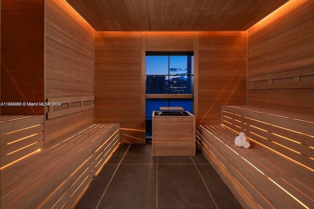 view of sauna with wooden walls, wooden ceiling, and tile patterned flooring