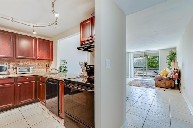 kitchen featuring decorative backsplash, range hood, sink, black appliances, and light stone counters