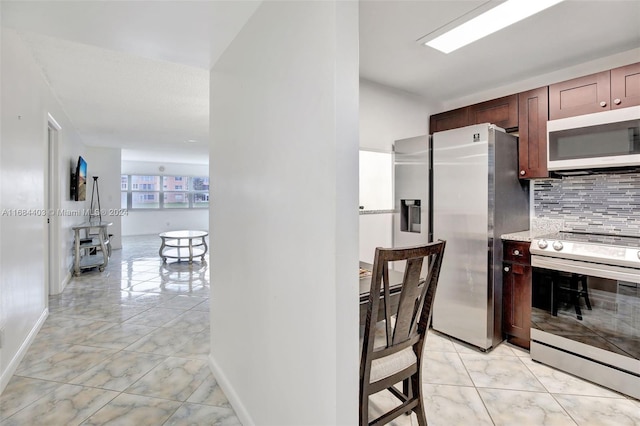 9540 Sunrise Lakes Blvd Unit 103, Sunrise, FL 33322 - kitchen featuring stainless steel appliances, light marble finish floors, decorative backsplash, and baseboards