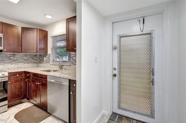 kitchen featuring sink, light stone counters, stainless steel appliances, and backsplash