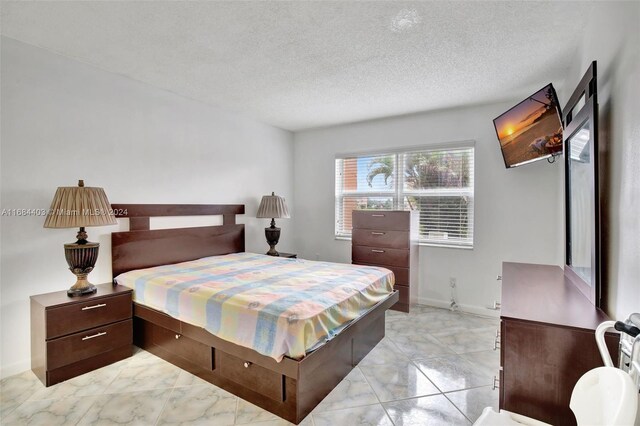 9540 Sunrise Lakes Blvd Unit 103, Sunrise, FL 33322 - bedroom with light marble finish floors, a textured ceiling, and baseboards