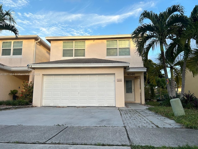 view of front facade with stucco siding, concrete driveway, and an attached garage