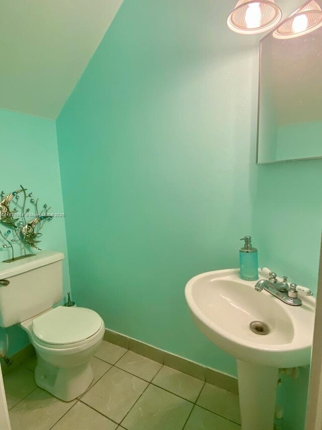 bathroom with tile patterned flooring, lofted ceiling, and toilet