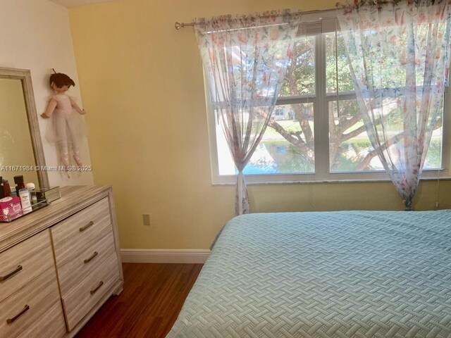 bedroom featuring dark hardwood / wood-style flooring and multiple windows