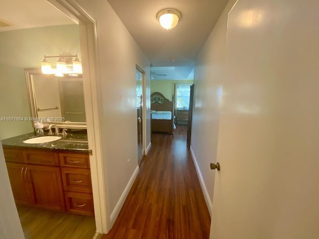 4046 Eastridge Dr, Deerfield Beach, FL 33064 - corridor featuring dark wood finished floors, baseboards, and a sink