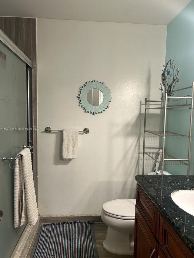 4046 Eastridge Dr, Deerfield Beach, FL 33064 - bathroom featuring vanity, toilet, and wood finished floors
