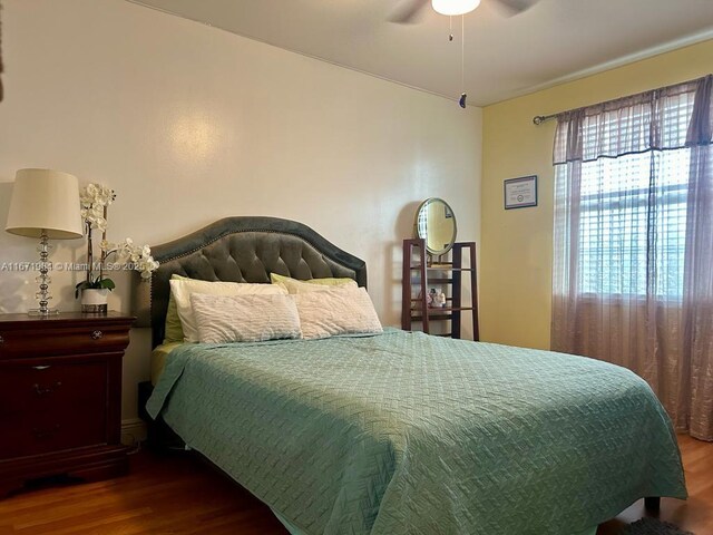 bedroom featuring a tray ceiling, ceiling fan, and dark wood-type flooring