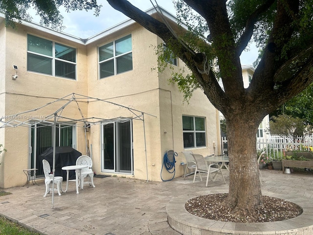 4046 Eastridge Dr, Deerfield Beach, FL 33064 - rear view of house with a patio area, stucco siding, and fence