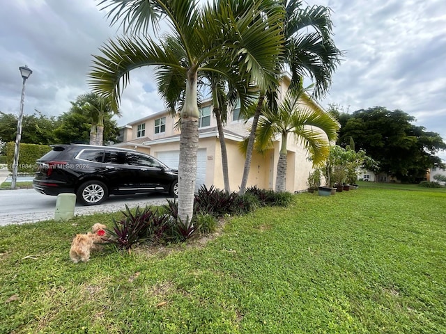 view of side of property with a lawn and a garage