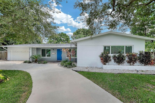 single story home featuring a front lawn and a garage