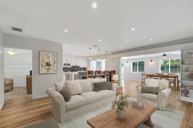 living room with ceiling fan and light hardwood / wood-style flooring